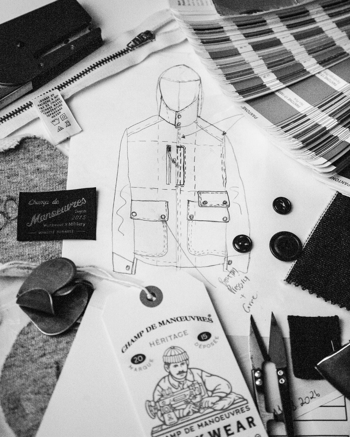 Croquis d'une veste à l'atelier, étiquettes, boutons et nuancier