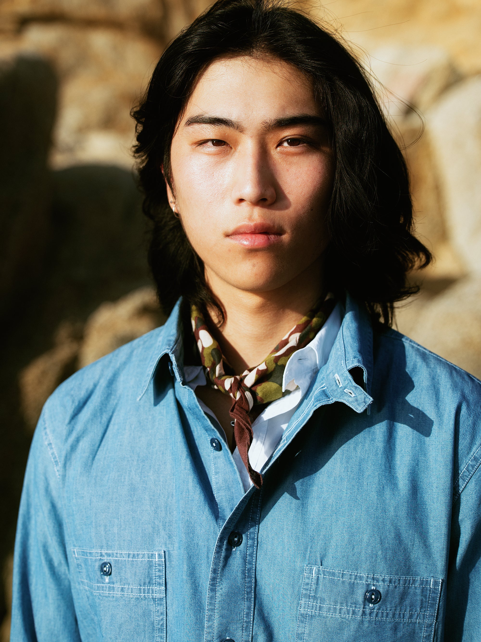 Chemise de travail en denim bleu clair Champ de Manoeuvres portée avec foulard motif camouflage, vêtement authentique inspiré du workwear"