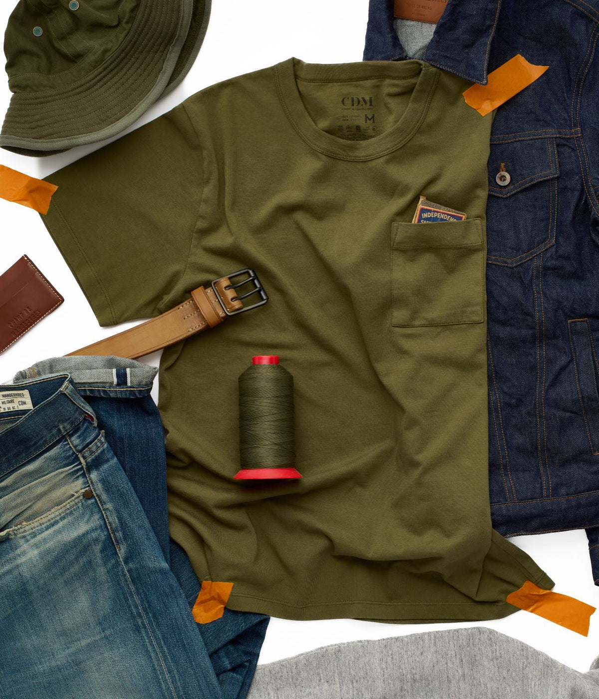 T-shirt kaki porté avec jean brut, ceinture et bob