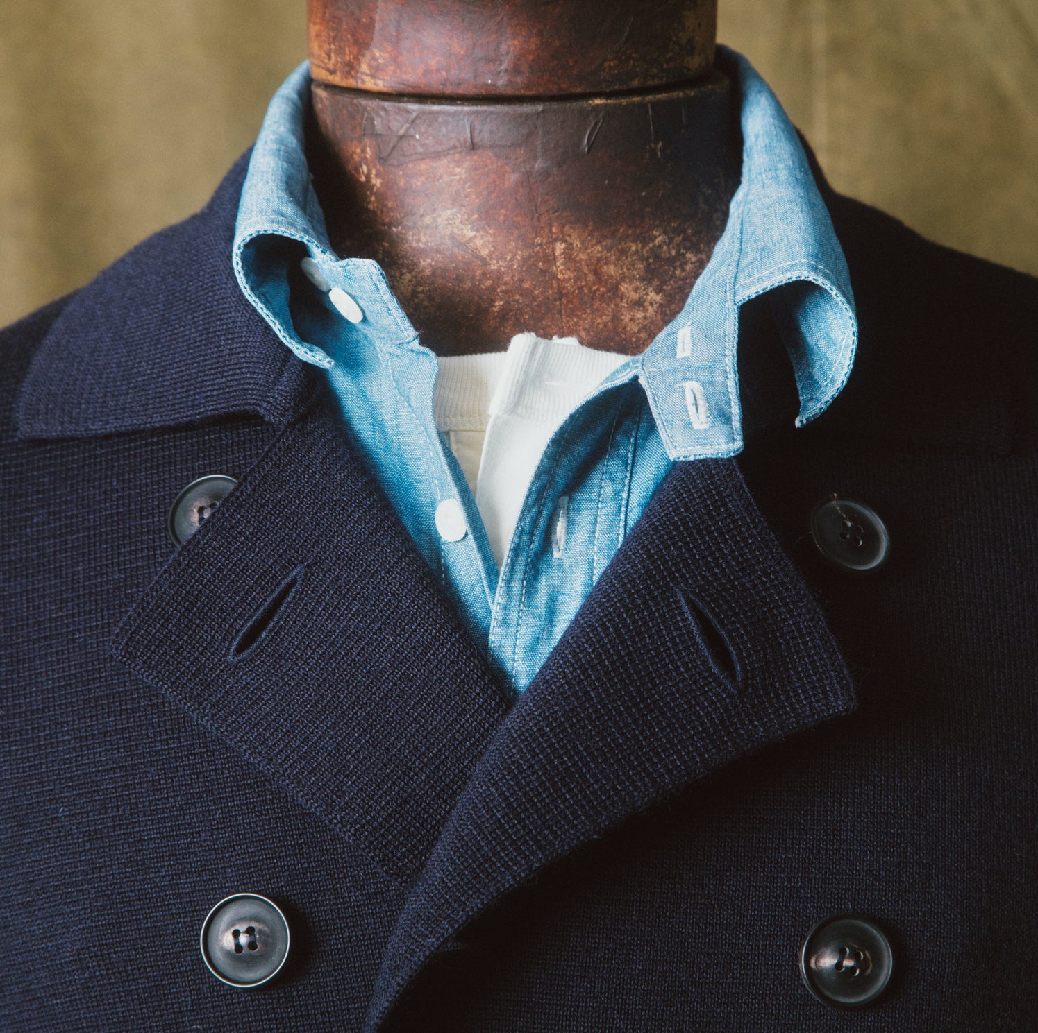 zoom sur le col croisé de notre pull croisée en maille milano de couleur bleu nuit.