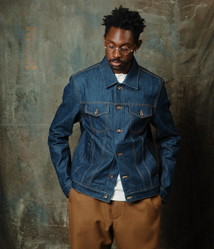 veste jeans bleu pétrole de la marque champ de manoeuvres, porté un mannequin dans un atelier.