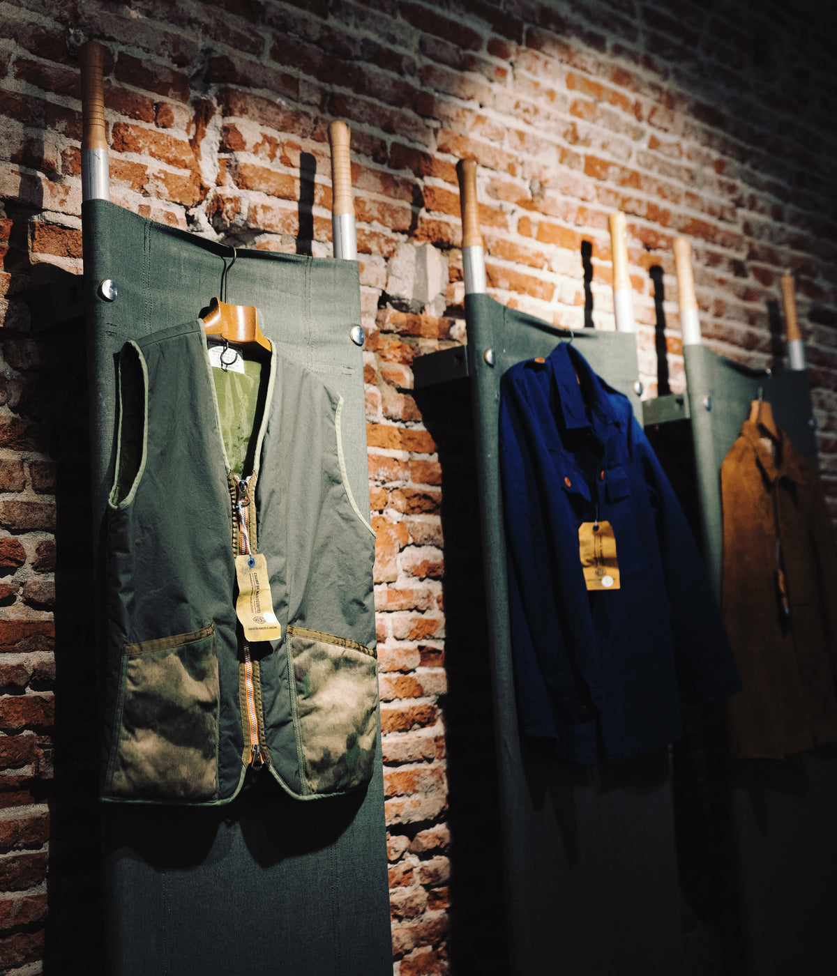 Gilet de chasse et vestes de travail le long du mur de brique, boutique Champ de Manœuvres à Toulouse