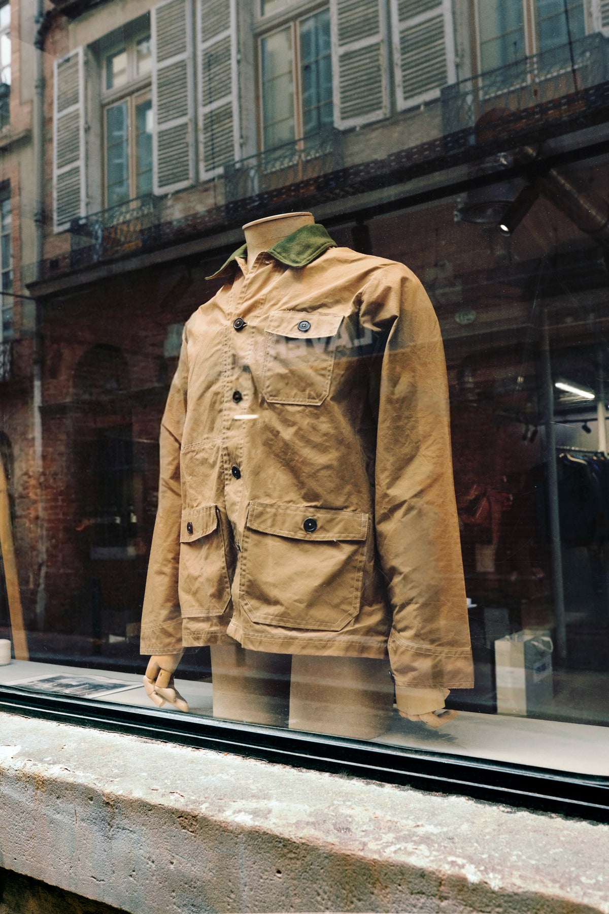 Veste de travail en toile waxée présentée en vitrine, boutique Champ de Manœuvres à Toulouse