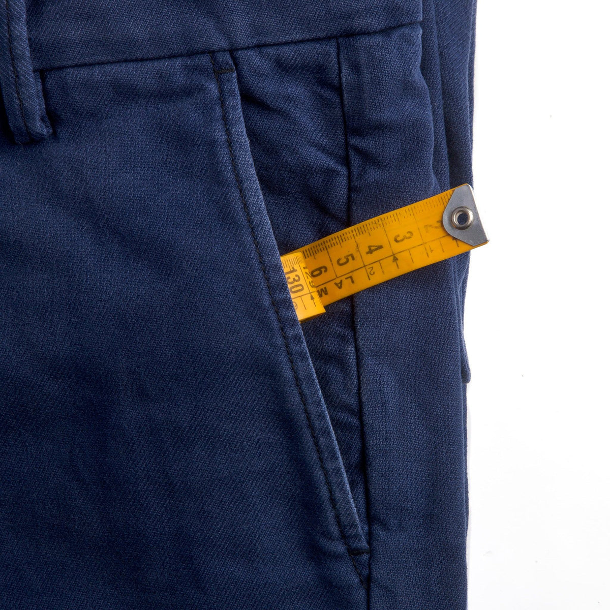 Détail de la poche italienne du Chino Slack Hydron bleu, mètre ruban de couturier glissé dans l'ouverture