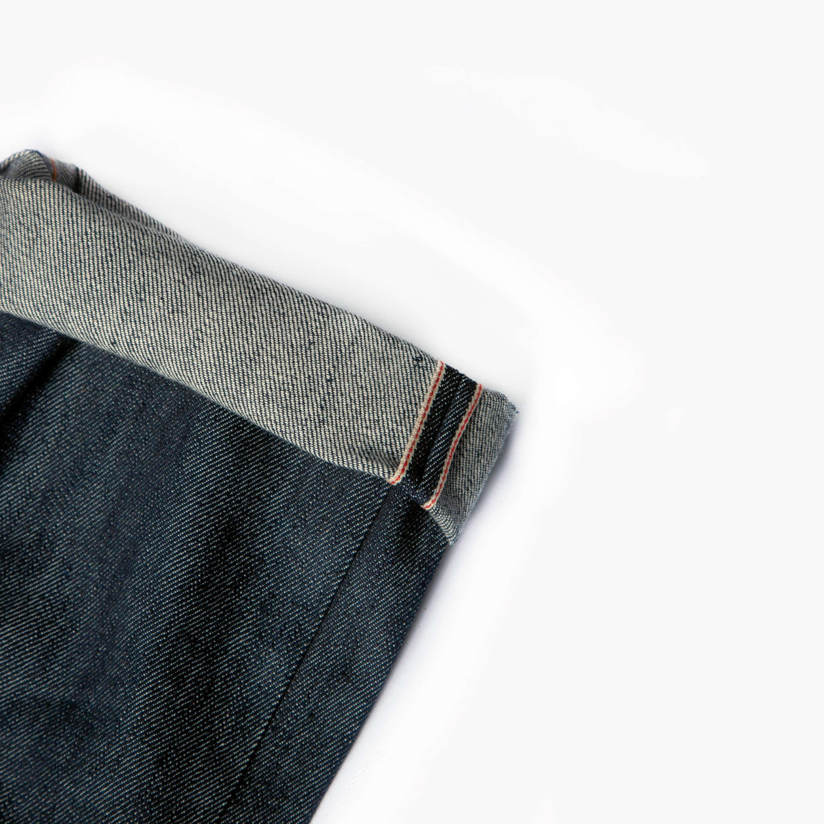 Détail de l'ourlet roulé du Jeans selvedge 13 oz montrant la lisière selvedge et son fil orange