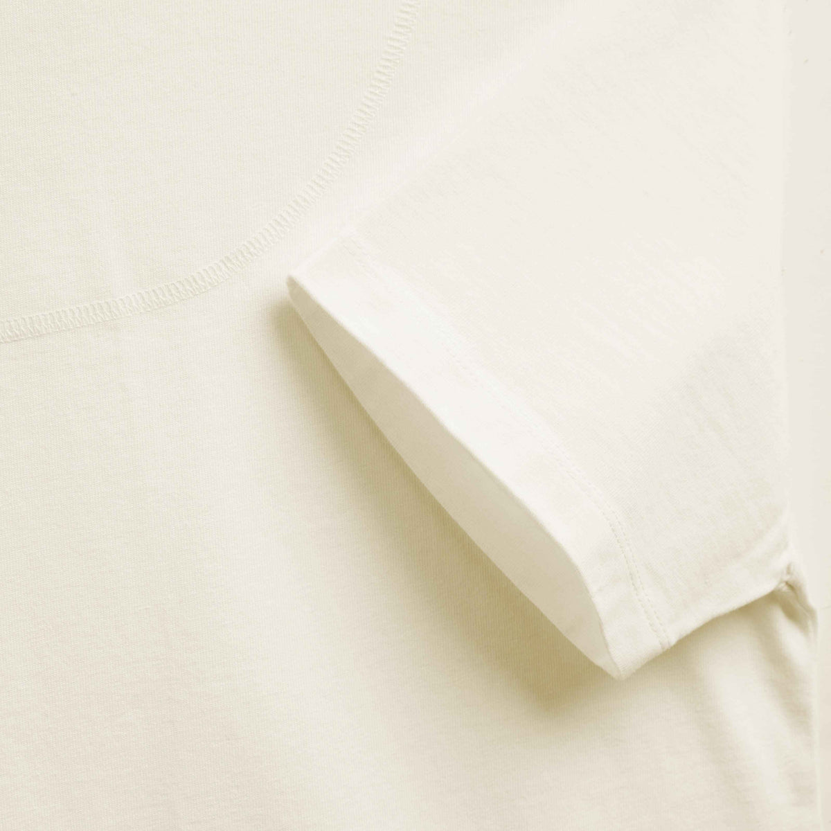 Détail du bas de manche et de la couture de colletage du T-shirt offwhite en jersey de coton